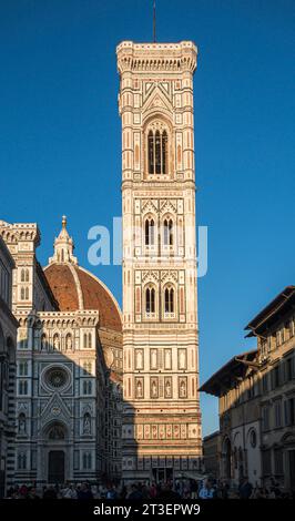 Florenz, Italien. Der von Giotto entworfene Campanile (Glockenturm), der zwischen 1334 und 1359 gebaut wurde, mit einem Teil des duomo (Kathedrale), im Abendlicht Stockfoto