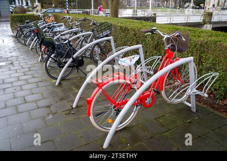 ZWOLLE, NIEDERLANDE - 14. MÄRZ 2021: Bemerkenswertes rotes Fahrrad parkt in einem Fahrradschuppen Stockfoto