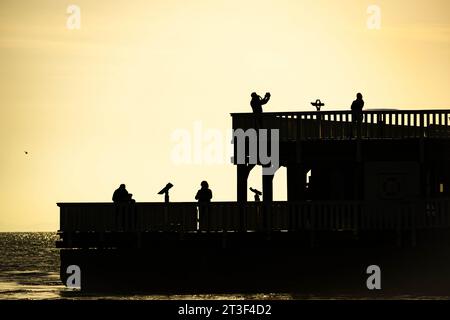 25. Oktober 2023, Niedersachsen, Cuxhaven: Passanten stehen am frühen Morgen auf der Aussichtsplattform „Alte Liebe“. Foto: Sina Schuldt/dpa Stockfoto