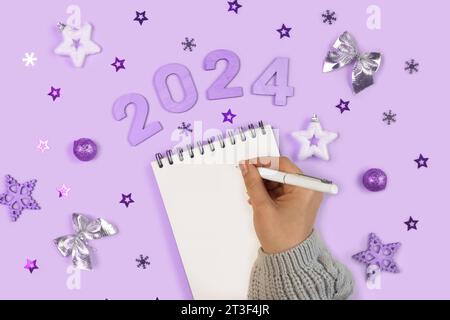 Neujahrsziele 2024. Aufgabenliste. Leeres Notizbuch am Schreibtisch mit Weihnachtsdekoration. Draufsicht. Weibliche Hand Erstellt Plan, Lösung. Neues Leben, Start U Stockfoto