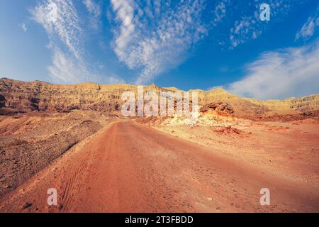 Fahren eines Autos auf einer unbefestigten Straße in der Wüste. Blick auf die Sandsteinberge durch die Windschutzscheibe. Timna Park, Israel Stockfoto