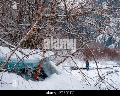 Winterberglandschaft mit einem Fotografen. Ein Mann mit einer Kamera auf einem Stativ fotografiert Bilder von Naturschauplätzen Stockfoto