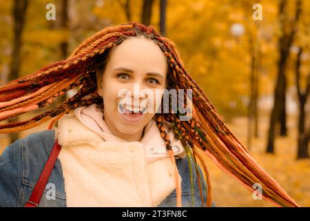 Porträt einer jungen Frau mit Dreadlocks im Herbstpark. Stockfoto