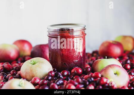 Hausgemachte Preiselbeerapfelkonserven in Dosen mit frischem Obst. Selektiver Fokus mit extrem verschwommenem Vorder- und Hintergrund. Stockfoto