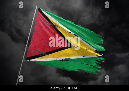 Guyana zerrissene Flagge auf dunklem Himmel Hintergrund. Stockfoto