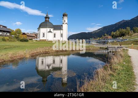 19.10.2023/Seefeld in Tirol, Österreich/Bild: Seekirche heiliges Kreuz, Seekirchl, Heiligkreuzkirche/vorne: Raabach, kleiner Bach/re.: Kongresszentrum Seefeld, Olympia Kongress, Olympiakongresszentrum, Olympia Sport- und Kongresszentrum, Olympiabad Seefeld/im Hintergrund re.: Skigebiet Rosshütte im Herbst *** 19 10 2023 Seefeld in Tirol, Österreich Bild Seekirchl, Heiligkreuzkirche vor Raabach, kleiner Bach Re Kongresszentrum Seefeld, Olympia Kongresszentrum, Olympia Sport- und Kongresszentrum Olympia, Olympiabad Seefeld im Hintergrund Re Ski A Stockfoto