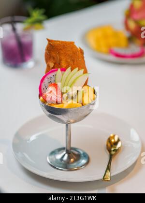Tropical Paradise Sorbet mit Grapefruit, Mango, Passionsfrucht dekoriert mit frischem Obst und knusprigen Tuilkeksen. Tropisches Eis in einer Eisschale aus Metall. Sommereis-Konzept Stockfoto