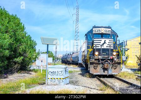 NEW ORLEANS, LA, USA – 21. OKTOBER 2023: Front der entgegenkommenden Norfolk Southern Lokomotive zieht Fracht über die Chartres Street Stockfoto