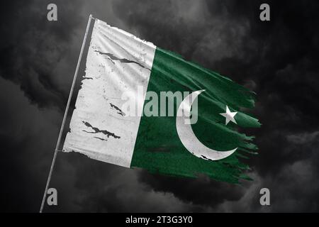 Pakistan zerrissene Flagge auf dunklem Himmel Hintergrund. Stockfoto