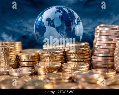 Investieren Sie weltweit Geld. Stapel Münzen und Globus im Hintergrund. Stockfoto