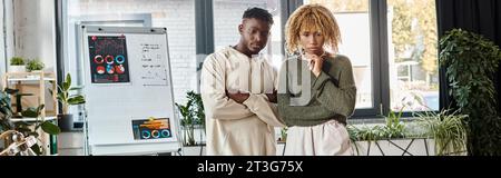 Nachdenkliche afroamerikanische Freunde in lässigen Outfits, die zusammen arbeiten, Business-Konzept, Banner Stockfoto