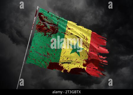 Senegal zerrissene Flagge auf dunklem Himmel Hintergrund mit Blutflecken. Stockfoto