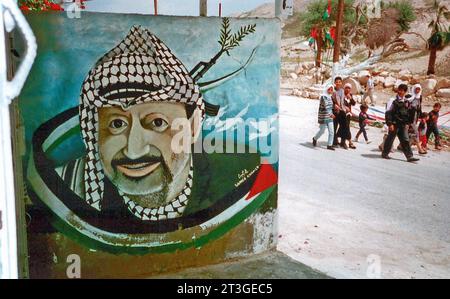 Archivfoto vom Frühjahr 1996 als Symbolbild zum Krieg zwischen der Hamas und Israel: Ein Wandgemälde im Westjordanland zeigt Jassir Arafat 1929 - 2004 mit Palästinensertuch und Friedenssymbolen. Der palästinensische Politiker und Friedensnobelpreisträger von 1994 führte die Palästinensische Befreiungsorganisation PLO, war erster Präsident der palästinensischen Autonomiegebiete sowie Gründer und Anführer der palästinensischen Fatah. *** Archivfoto vom Frühjahr 1996 als symbolisches Bild des Krieges zwischen Hamas und Israel Ein Wandbild im Westjordanland zeigt Jassir Arafat 1929 2004 mit Palästinensern Stockfoto