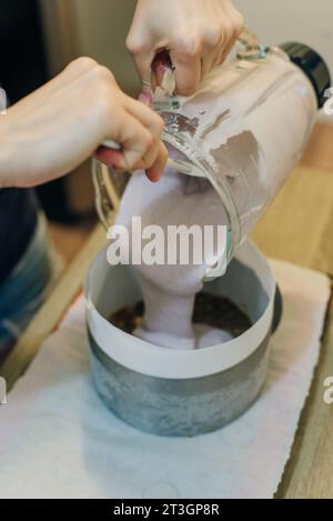 Die Frau hält ein Glas Weißcreme für den Kuchen. Füllt den Kuchen mit Sahne. Hochwertige Fotos Stockfoto