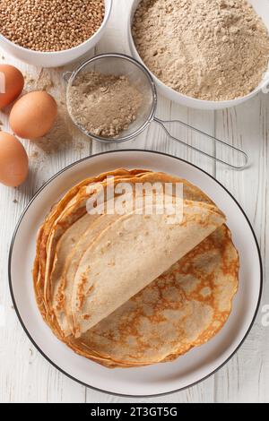 Französische Buchweizen-Crepes glutenfrei und mit einem schönen leicht nussigen Geschmack aus der Nähe auf dem weißen Holztisch. Vertikale Draufsicht von oben Stockfoto