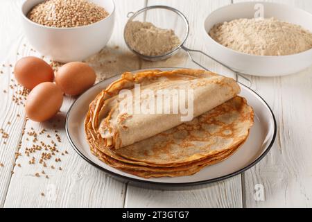 Französische Buchweizengalette Pfannkuchen auf einem Teller mit Zutaten auf einem Holztisch. Horizontal Stockfoto