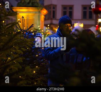 Heidelberg – 19. Dezember 2022: Jüngere Menschen im Gespräch mit Freunden auf dem Weihnachtsmarkt im Winter Stockfoto