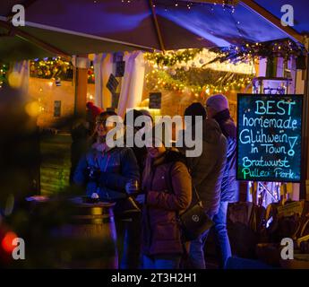 Heidelberg – 19. Dezember 2022: Jüngere Menschen im Gespräch mit Freunden auf dem Weihnachtsmarkt im Winter Stockfoto