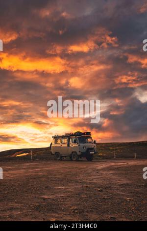 Der Minibus parkte mit wunderschönem Sonnenunterganghimmel auf dem Gipfel des Berges im isländischen Hochland im Sommer auf Island Stockfoto