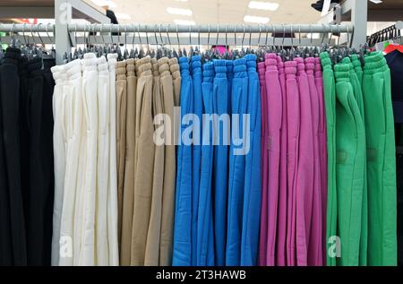 Schöne Damenhosen hängen an Kleiderbügeln, verkauft in einem Modegeschäft. Nahaufnahme. Stockfoto