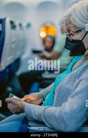 Denver, Colorado - Susan Newell, 74, liest aus ihrem Kindle, während sie auf ihren Flug der Southwest Airlines vom Denver International Airport wartet Stockfoto