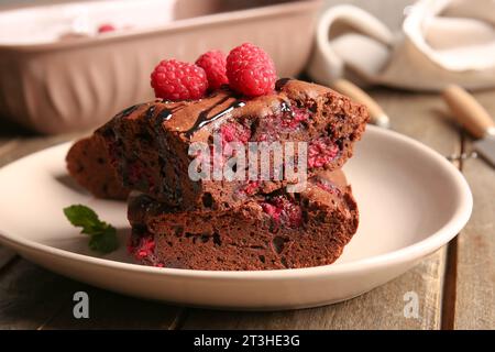 Teller mit Himbeer-Schokoladen-Brownie auf Holztisch Stockfoto
