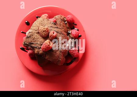 Teller mit Himbeer-Schokoladen-Brownie auf rotem Hintergrund Stockfoto