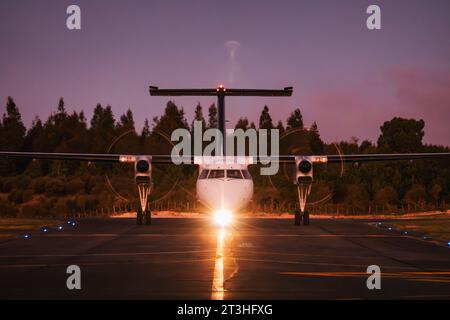 Ein Air New Zealand Q300 'Dash 8' Turboprop-Flugzeug parkt in einer klaren Nacht am Flughafen Taupō in Neuseeland Stockfoto