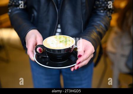 Nahaufnahme einer Frau, die eine Tasse Kaffee gibt Stockfoto