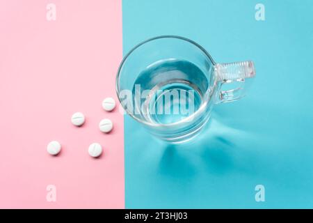 Pillen auf türkisfarbenem und rosa Hintergrund zur Prävention, Immunisierung und Behandlung der Coronavirus-Infektion (neue Coronavirus-Krankheit 2019, COVID-19 Stockfoto