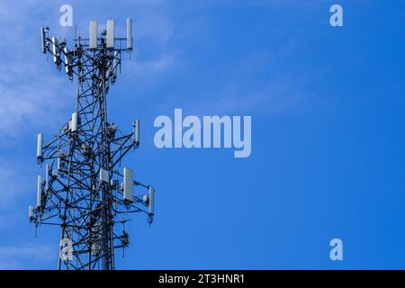 Ein Foto des oberen Teils eines Mobilfunkantenturms vor einem blauen Himmel mit Kopierraum. Stockfoto