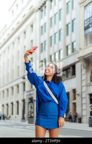 Glückliche Geschäftsfrau, die ein Selfie auf der Straße macht Stockfoto