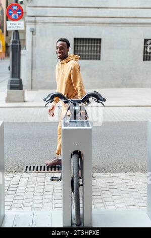 afroamerikaner, der lächelnd die Straße hinunter läuft Stockfoto