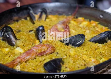 Frische Meeresfrüchte-Paella in traditioneller Gusseisenpfanne. Traditionelle spanische Paella mit Meeresfrüchten in einem valencianischen Restaurant. Stockfoto