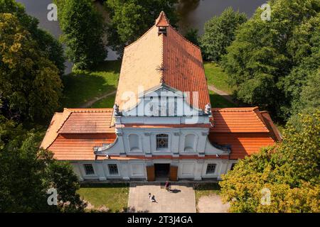 (ANMERKUNG DER REDAKTION: Bild mit einer Drohne) Drohnenansicht der Kirche auf dem Wasser in Zwierzyniec. Die Kirche am Wasser in Zwierzyniec wurde im 18. Jahrhundert erbaut und ihre Geschichte geht noch tiefer. Die Stadt Zwierzyniec gehörte zusammen mit den umliegenden Gebieten einst der Familie Firlej, die für ihre künstlerische und religiöse Schirmherrschaft bekannt war. Der Nationalpark Roztocze liegt im Südosten Polens in Roztocze, in der Woiwodschaft Lubelskie. Sie wurde am 10. Mai 1974 gegründet. Die Verwaltung des Parks befindet sich im Schloss des Bevollmächtigten in Zwierzyniec. (Foto von Mateus Stockfoto