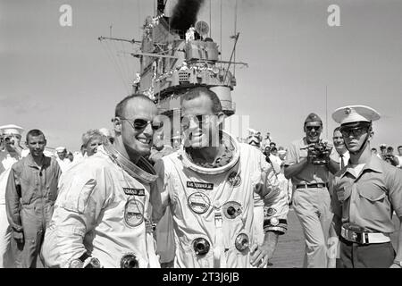 Die Astronauten L. Gordon Cooper Jr. (rechts) und Charles Conrad Jr. gehen über das Deck des Rückgewinnungsflugzeugträgers U.S.S. Lake Champlain, nachdem sie sich vom Meer erholen. Gemini 5 Stockfoto