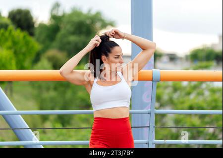 Frau, die sich beim Training die Haare bindet Stockfoto
