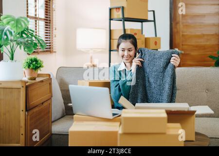 Schöne asiatische Frau, Blogger, Blog, Modebekleidung präsentieren, Live-Video, Soziale Medien, Aufnahme, Online-Verkauf über Digitalkameras, kmu oder kleine unternehmen Stockfoto