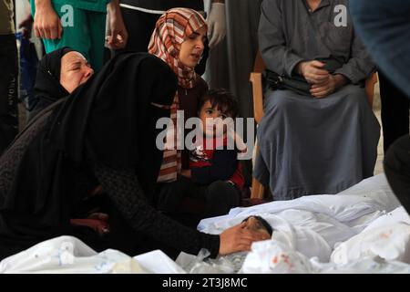 Rafah, Gaza. Oktober 2023. Die Menschen trauern um die Leichen von Verwandten, die am Mittwoch, den 25. Oktober 2023, in Rafah im südlichen Gazastreifen bei israelischen Bombardements getötet wurden. Die Zahl der Todesopfer durch israelische Streiks im Gazastreifen ist auf fast 7.000 gestiegen, sagte das palästinensische Gesundheitsministerium. Foto: Ismael Mohamad/UPI. Quelle: UPI/Alamy Live News Stockfoto