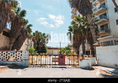 Ein mehrsprachiges Warnschild an einem Tor zu einem Sperrgebiet in der Nähe von Varosha, Famagusta, Nordzypern Stockfoto