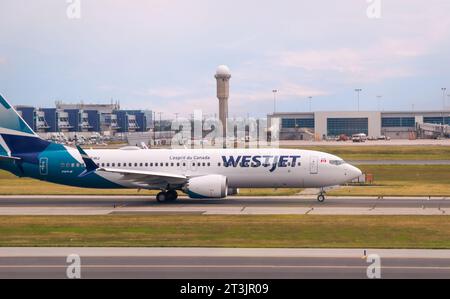 Montreal, Quebec, Kanada - 07 04 2022 : Boeing 737 MAX 8 Jet-Flugzeug von WestJet Airlines auf der Landebahn des Flughafens Montreal. WestJet Airlines Stockfoto