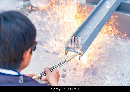 Arbeiter schneidet Balken mit Acetylenbrenner auf der Baustelle. Stockfoto