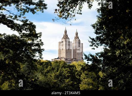 Die Türme der San Remo Apartments in New York City, eingerahmt von den Bäumen im Central Park vor blauem Himmel mit Wolken. Stockfoto