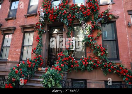 Skelette krabbeln am Äußeren dieses Greenwich Village Stadthauses hoch, das mit Rosen bedeckt ist, in New York, New York, Mittwoch, 25. Oktober 2023. (Foto: Gordon Donovan) Stockfoto
