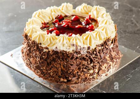 Kirschtorte aus schwarzem Wald mit Schokoladenschwamm, Kirschkompott und Chantilly-Creme. Dekoriert mit Schokoladenflocken. Stockfoto