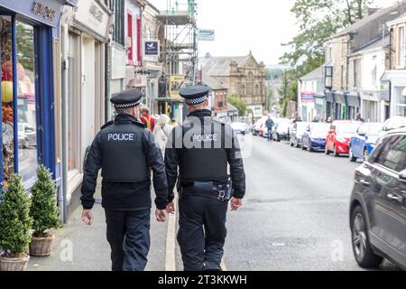 Britische Polizeibeamte, die im Zentrum von Clitheroe Lancashire während der Ribble Valley Roller-Rallye auf dem Beat laufen, England, Großbritannien, 2023 Stockfoto