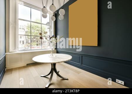 Ein Raum mit blauen Wänden und Holzfußboden, einschließlich eines weißen runden Esstisch, der von zwei Hängelampen umgeben ist Stockfoto