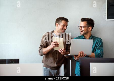 Lächelnd treffen sich verschiedene Kollegen in einem Brainstorming in der Vorstandsetage, um gemeinsam Finanzstatistiken zu diskutieren Stockfoto
