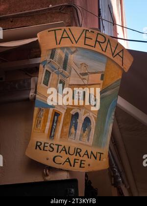 KORFU, GREEECE - 11. SEPTEMBER 2023: Buntes Schild vor dem Taverna Restaurant im Stadtzentrum Stockfoto