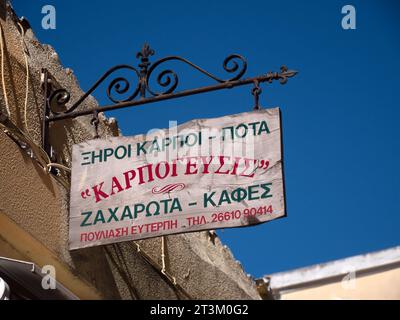 KORFU, GREEECE - 11. SEPTEMBER 2023: Altes hölzernes Schild mit griechischem Text im Stadtzentrum Stockfoto